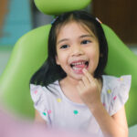 young-girl-sits-dentist-chair-smiles